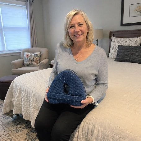 Customer holding the Aline knee pillow in her bedroom