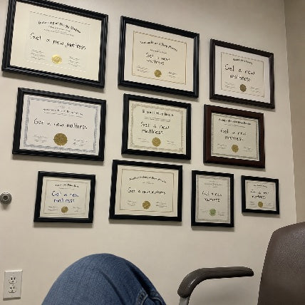 Wall of framed doctor's certificates all reading 'Get a new mattress'